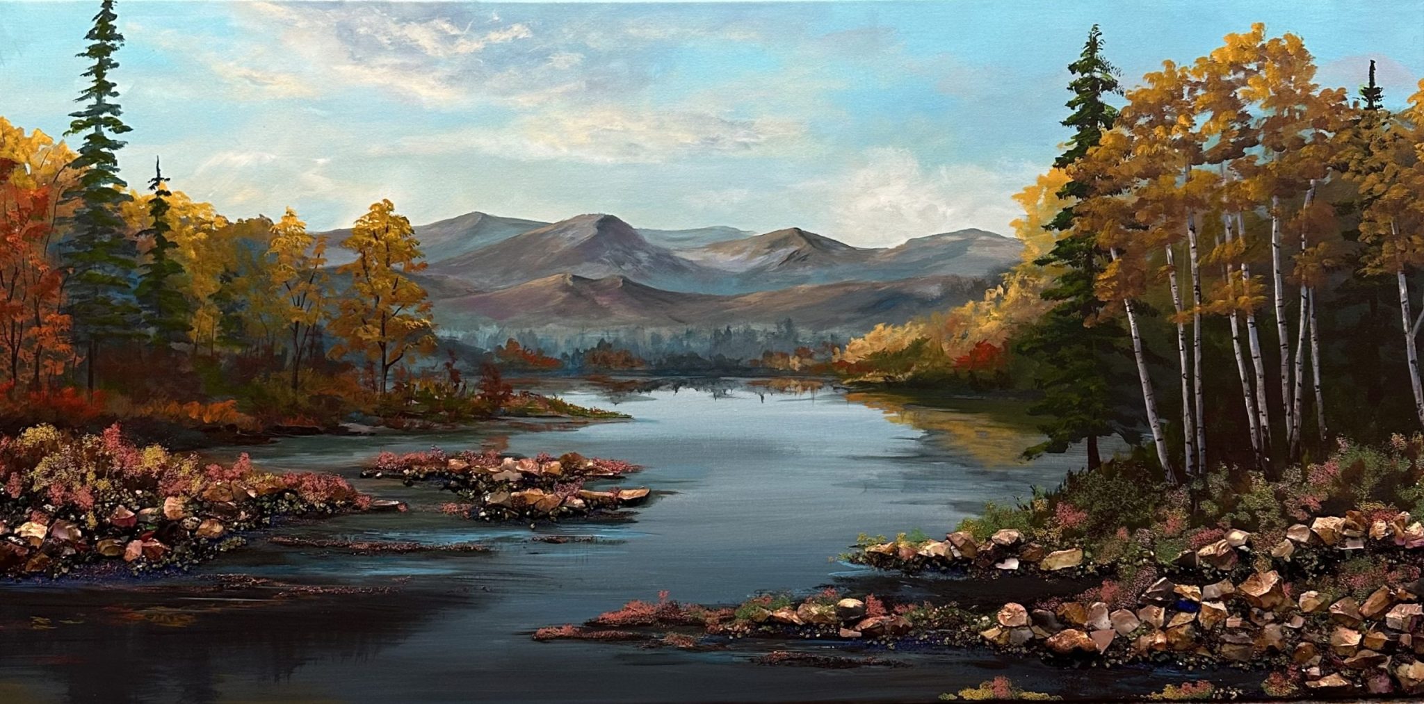 Fall landscape with aspen trees, calm water and soft mountains in the distance.