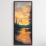 Acrylic sunrise landscape with an elk standing in glowing water, silhouetted trees, distant blue mountains, and birds crossing the sky; framed in a bronze metal floater frame.