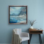 Winter landscape in soft blues with shimmering ice, trees, and subtle sparkle; framed in a chrome floater frame above a holiday mantel.