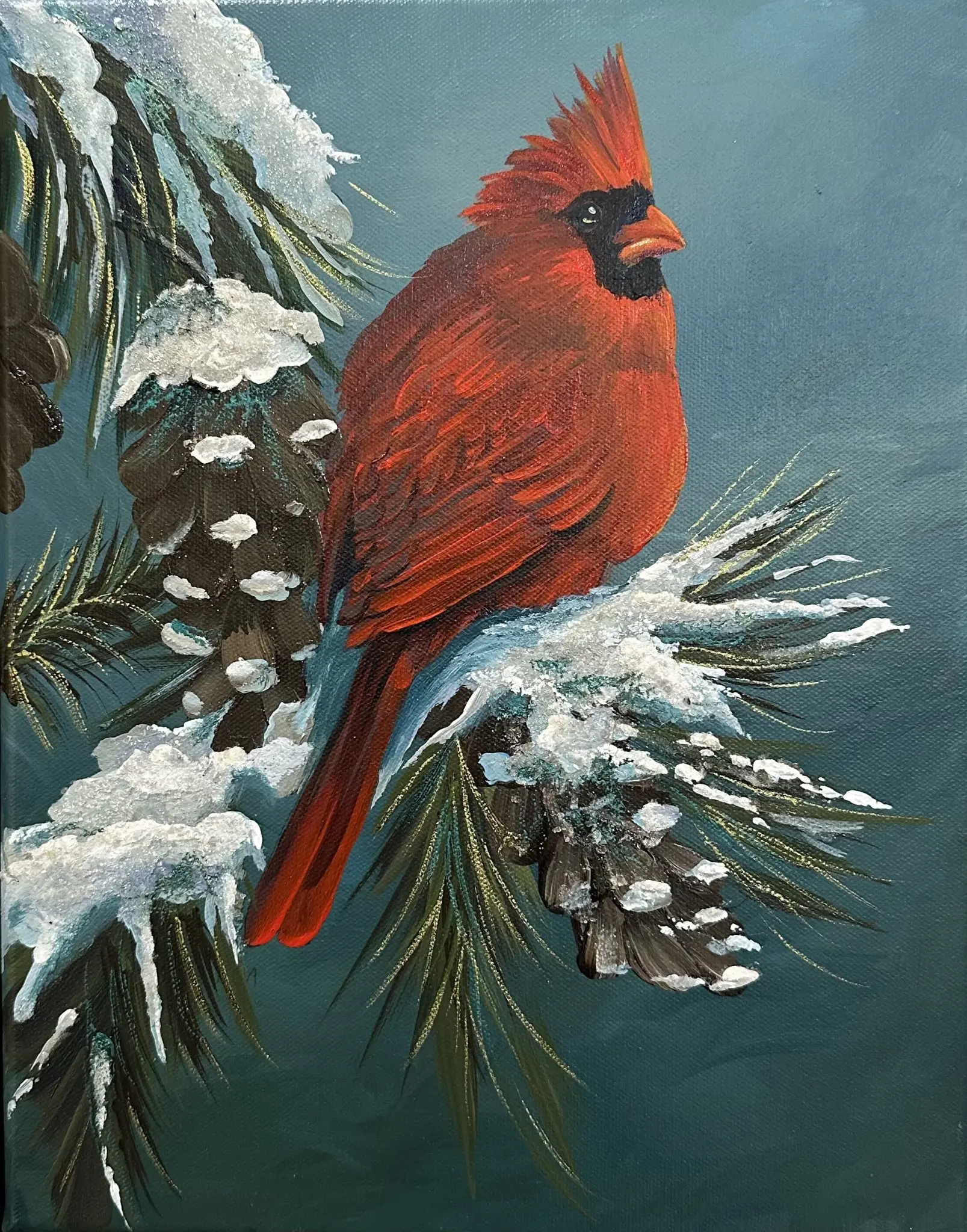 Crimson Serenade (1) A vibrant red cardinal sits on a snow-covered pine branch in a teal winter sky. Mica and glass glitter add shimmering highlights to the feathers and snow. The artwork is framed in a sleek black floater frame.